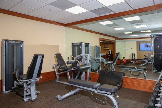 gym featuring ornamental molding and a drop ceiling