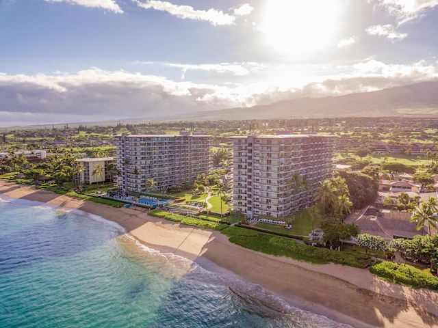 birds eye view of property with a water view and a beach view