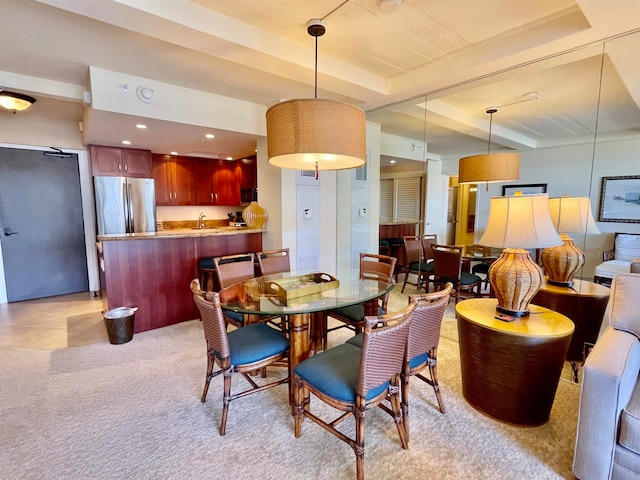 dining room with sink and a raised ceiling