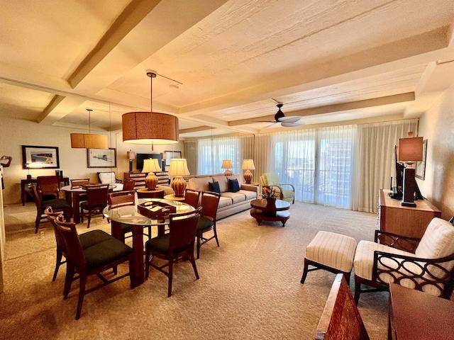 dining room with beamed ceiling, carpet flooring, and ceiling fan