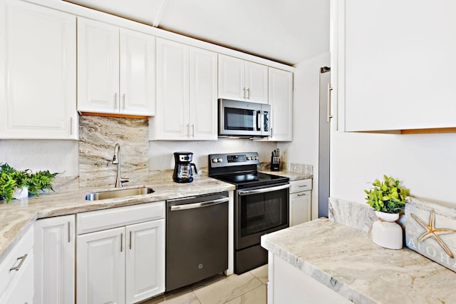 kitchen featuring decorative backsplash, white cabinetry, sink, and appliances with stainless steel finishes