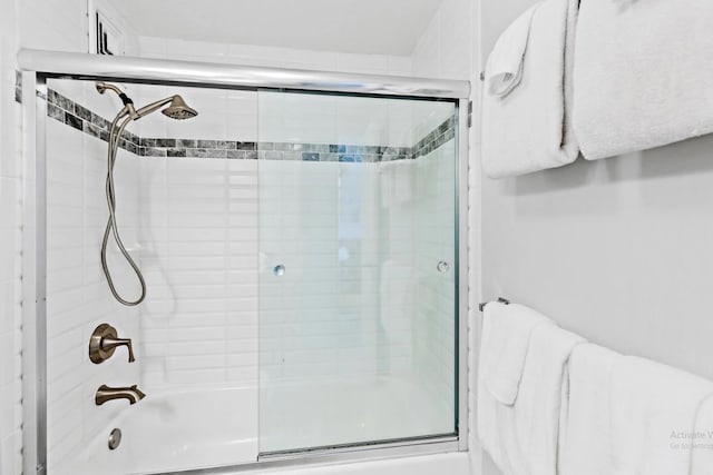 bathroom featuring combined bath / shower with glass door