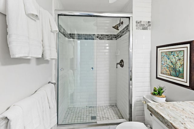 bathroom featuring toilet and a shower with door