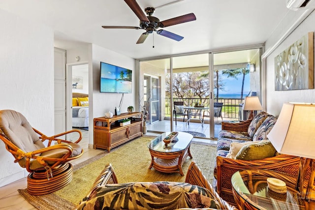 living room featuring ceiling fan and an AC wall unit