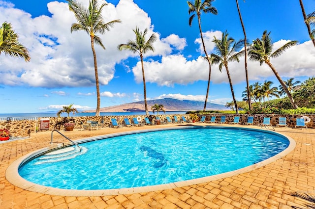 view of pool featuring a water and mountain view and a patio