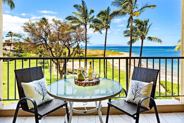 balcony featuring a view of the beach and a water view