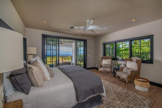 bedroom featuring access to outside, multiple windows, ceiling fan, and hardwood / wood-style flooring