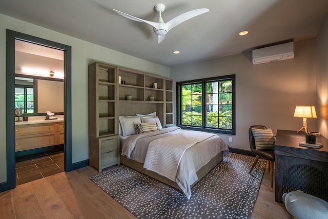 bedroom featuring ceiling fan, dark wood-type flooring, an AC wall unit, multiple windows, and connected bathroom