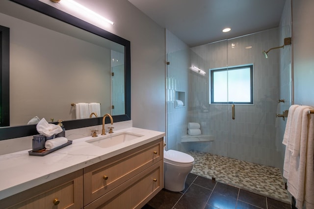 bathroom featuring tile patterned flooring, vanity, toilet, and a shower with shower door