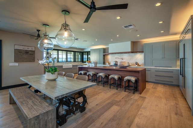 dining area with ceiling fan and light wood-type flooring