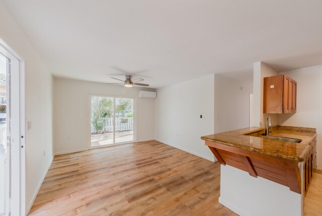 160 Keonekai Rd Unit 9-102, Kihei, HI 96753 - interior space with a wall mounted AC, sink, a healthy amount of sunlight, and light hardwood / wood-style flooring