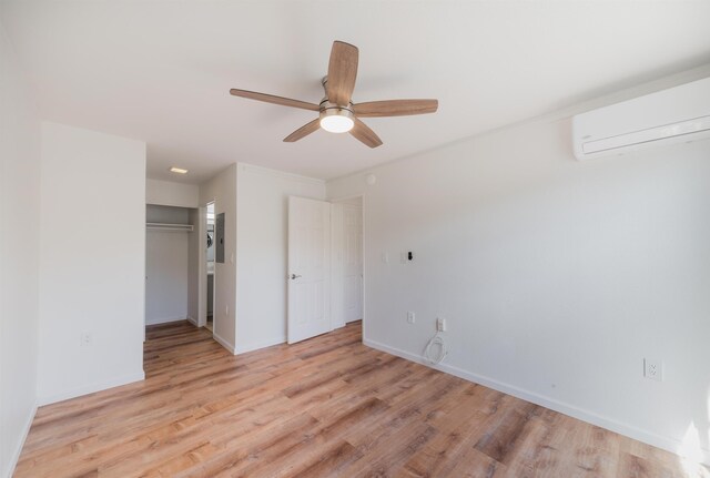 160 Keonekai Rd Unit 9-102, Kihei, HI 96753 - unfurnished bedroom featuring a wall mounted AC, ceiling fan, a spacious closet, light hardwood / wood-style floors, and a closet