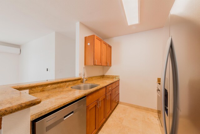 160 Keonekai Rd Unit 9-102, Kihei, HI 96753 - kitchen with light stone countertops, sink, stainless steel appliances, an AC wall unit, and kitchen peninsula