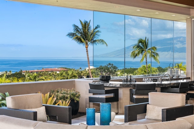 view of patio / terrace with a balcony, a water view, and outdoor wet bar