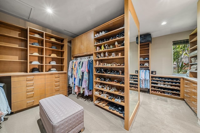 walk in closet featuring light colored carpet