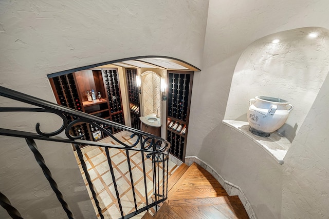 stairway with a textured wall and wood finished floors