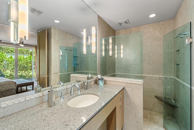 ensuite bathroom with ensuite bathroom, vanity, a shower stall, and visible vents