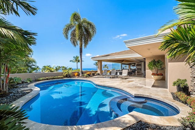 view of pool featuring fence private yard, a pool with connected hot tub, and a patio