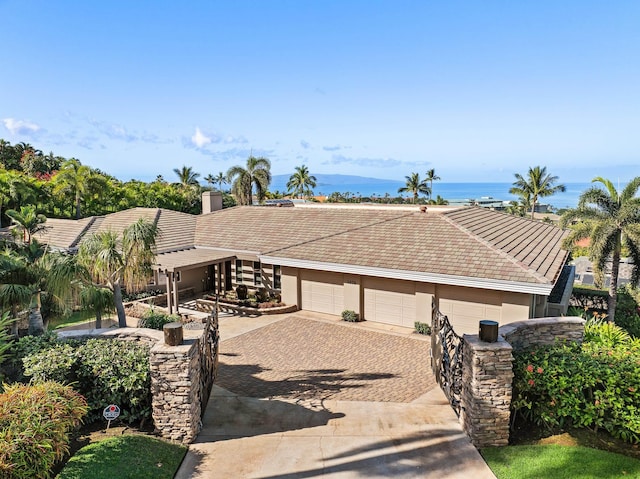 view of front of home featuring a garage, a tile roof, driveway, and stucco siding