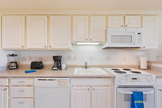 kitchen with a sink, white appliances, tasteful backsplash, and white cabinetry