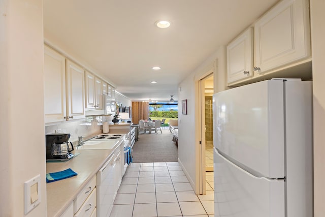 kitchen featuring tasteful backsplash, light countertops, light tile patterned floors, recessed lighting, and white appliances