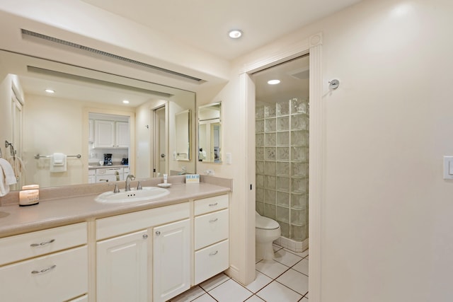 bathroom featuring vanity, tiled shower, recessed lighting, tile patterned flooring, and toilet