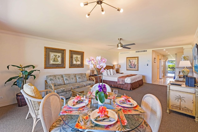 dining room with visible vents, crown molding, baseboards, light colored carpet, and ceiling fan with notable chandelier