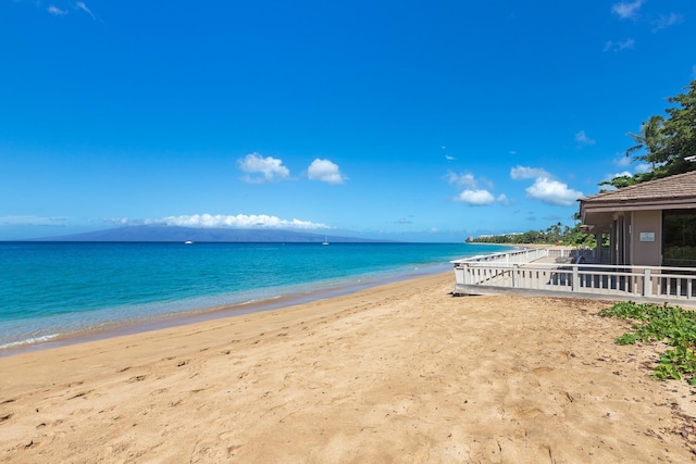 property view of water featuring a view of the beach and fence