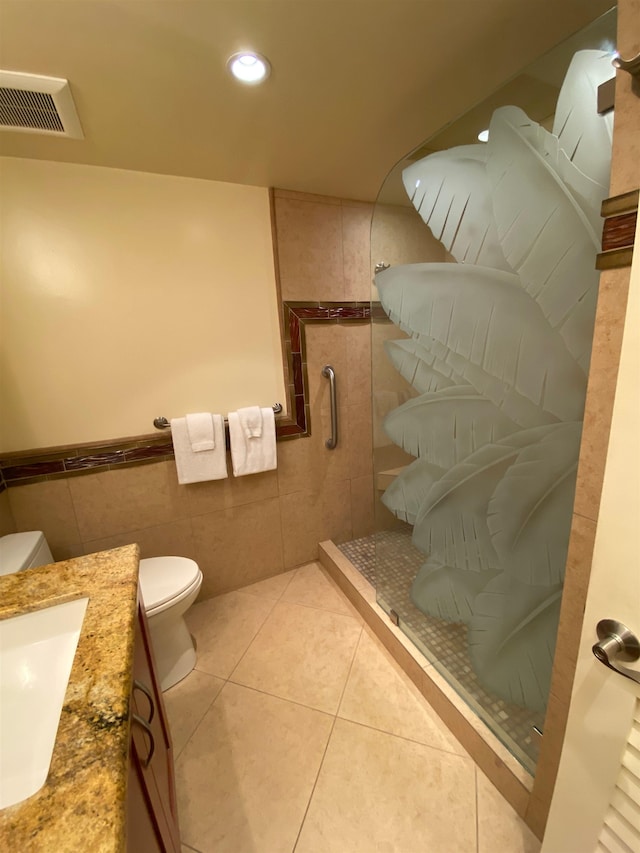 bathroom featuring tiled shower, tile patterned flooring, toilet, and vanity