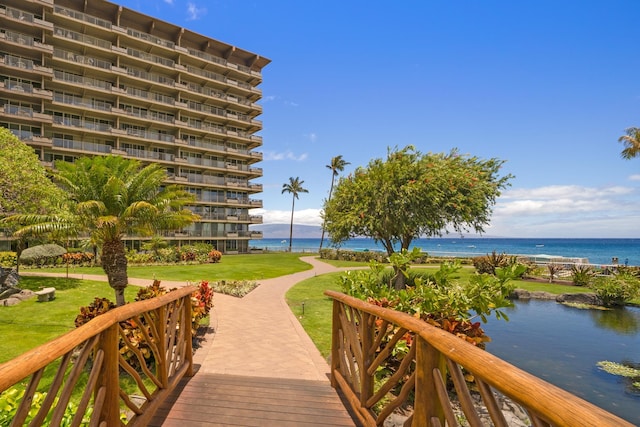 view of property's community featuring a yard and a water view