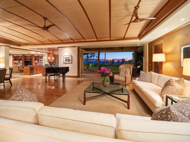 living room with wood ceiling, light hardwood / wood-style flooring, built in shelves, and ceiling fan