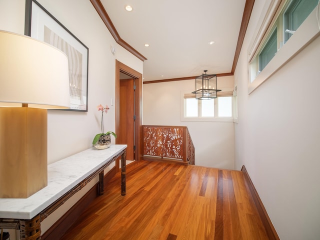 corridor featuring ornamental molding and hardwood / wood-style flooring