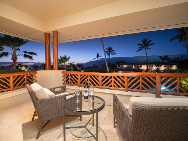 patio terrace at dusk featuring a mountain view and an outdoor living space