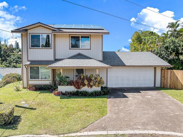 traditional-style home with driveway, a front lawn, roof mounted solar panels, fence, and a garage