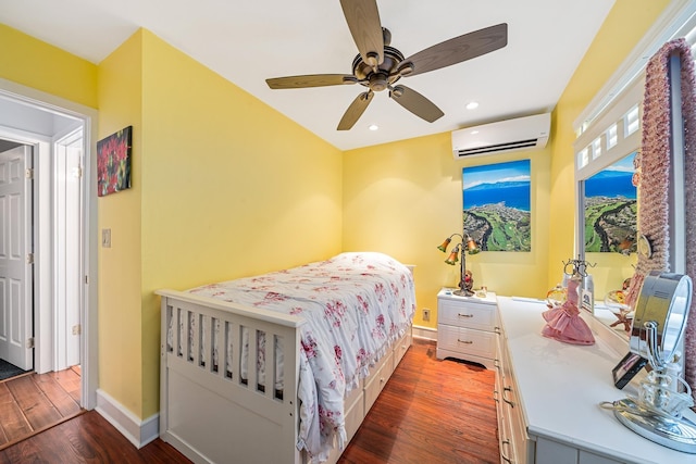 bedroom featuring dark wood finished floors, recessed lighting, baseboards, and a wall mounted air conditioner