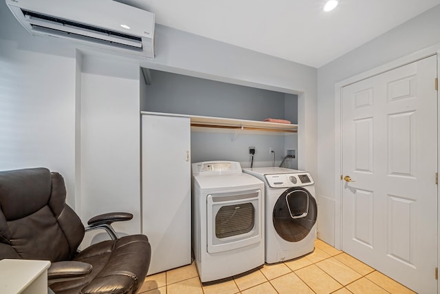 washroom with washer and dryer, a wall unit AC, light tile patterned floors, and laundry area