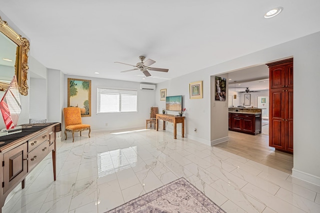 sitting room with baseboards, marble finish floor, a ceiling fan, and a wall unit AC