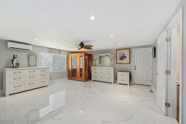 bedroom with baseboards, marble finish floor, a wall mounted air conditioner, and a textured ceiling