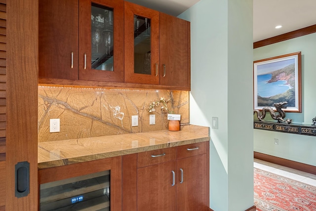 bar with light stone counters, beverage cooler, and tasteful backsplash