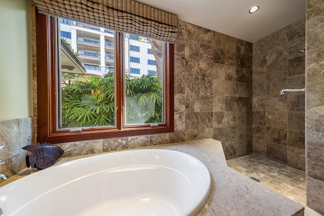 bathroom featuring independent shower and bath and tile walls