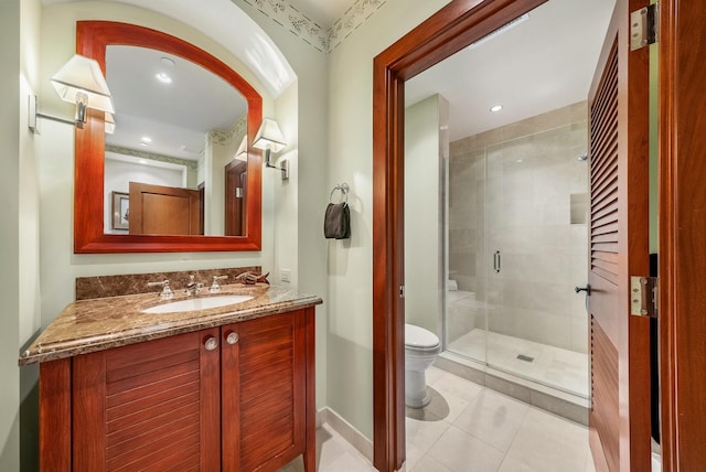 bathroom featuring vanity, toilet, tile patterned flooring, and walk in shower