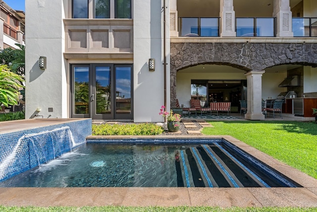 back of house featuring french doors, pool water feature, area for grilling, and a lawn