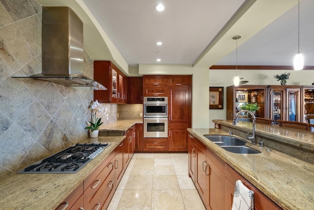 kitchen featuring light stone counters, sink, hanging light fixtures, and wall chimney range hood