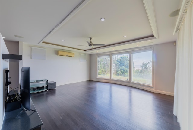 unfurnished living room with a wall mounted AC, a tray ceiling, plenty of natural light, and ceiling fan