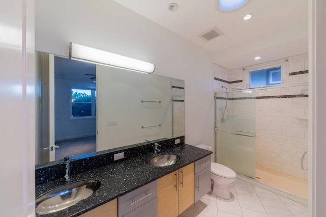 bathroom featuring tile patterned floors, vanity, toilet, and tiled shower