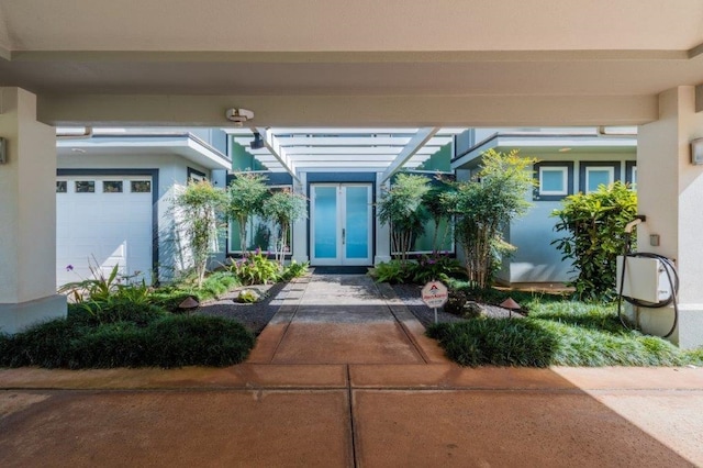 property entrance with a pergola and a garage