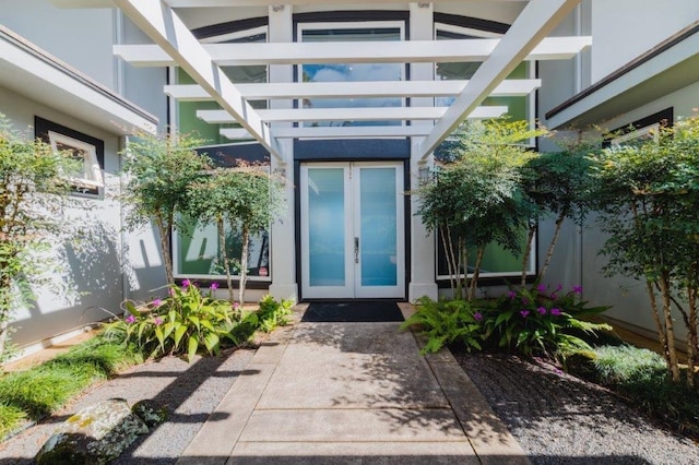 property entrance with a pergola and french doors