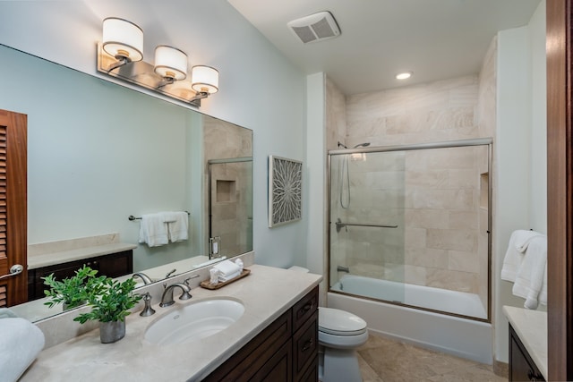 full bathroom featuring combined bath / shower with glass door, tile patterned floors, vanity, and toilet