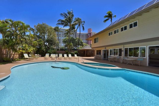 view of pool featuring an in ground hot tub and a patio