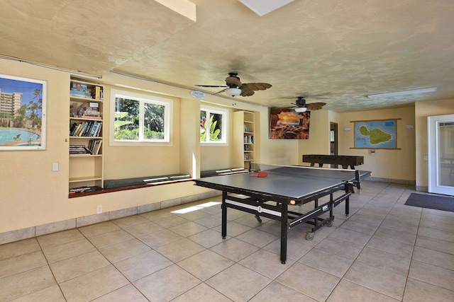 rec room featuring light tile patterned floors, a textured ceiling, and ceiling fan